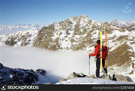 Male ski-climber at the summit of his climbing; horizontal frame. Italian alps.