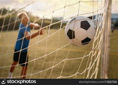 Male soccer goalkeeper missed the ball and got a goal. Footballer on outdoor stadium, workout before game, football training