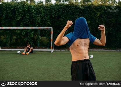 Male soccer player hits the goal on the field. Footballers on outdoor stadium, workout before game, football training