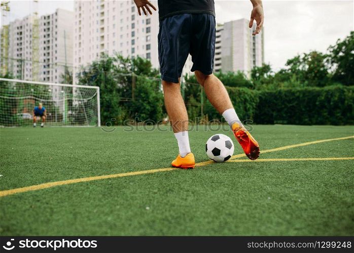 Male soccer player working with ball on the field. Footballer on outdoor stadium, workout before game, football training
