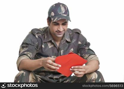 Male soldier holding greeting card over white background