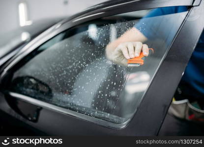 Male specialist work with car, tinting film installation process, tinted auto glass installing procedure