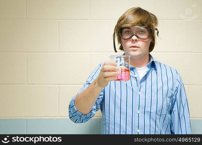 Male student holding chemical in flask