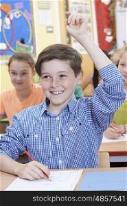 Male Student Raising Hand To Answer Question On Class