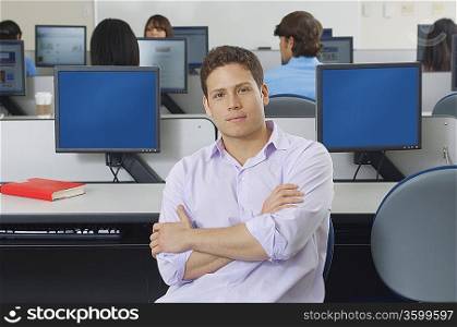Male student sitting in computer classroom, portrait