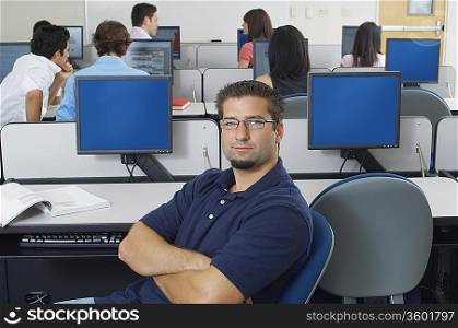 Male student sitting in computer classroom, portrait