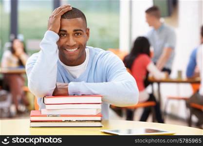 Male Student Studying In Classroom With Books