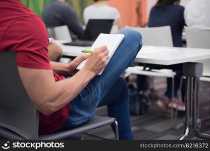 male student taking notes in classroom. business education concept, casual young businessman on seminar training