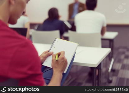 male student taking notes in classroom. business education concept, casual young businessman on seminar training