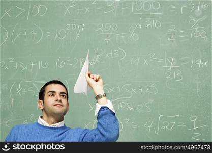 Male student throwing a paper aeroplane