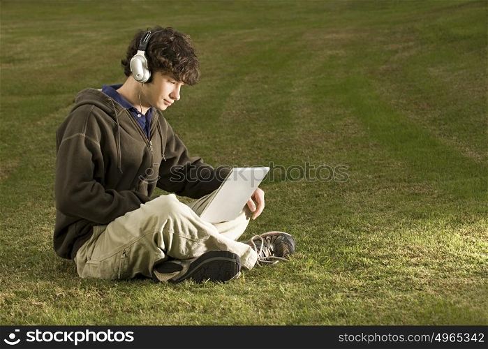 Male student using a laptop computer outdoors