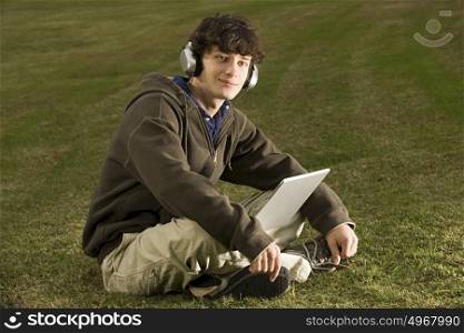 Male student using a laptop outdoors