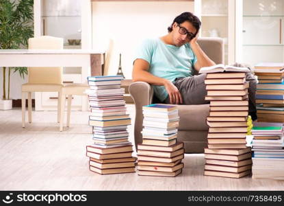 Male student with many books at home 