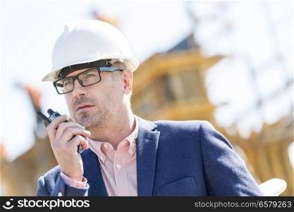 Male supervisor using walkie-talkie at construction site