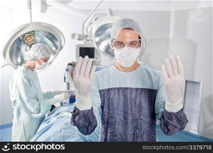 Male surgeon asking for gloves in middle of operation