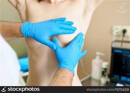 Male surgeon prepares woman for plastic surgery in clinic. Breast correction in hospital, professional diagnostic, mammologist. Medical specialist and patient, mammography. Male surgeon prepares woman for plastic surgery