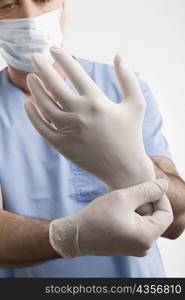 Male surgeon putting on surgical gloves