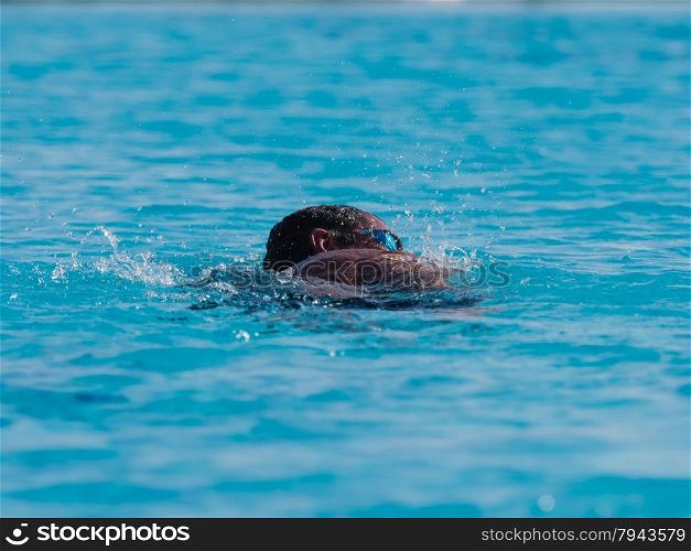 Male swimmer in blue pool