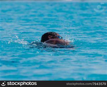Male swimmer in blue pool