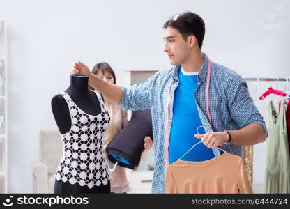 Male tailor with female student in workshop