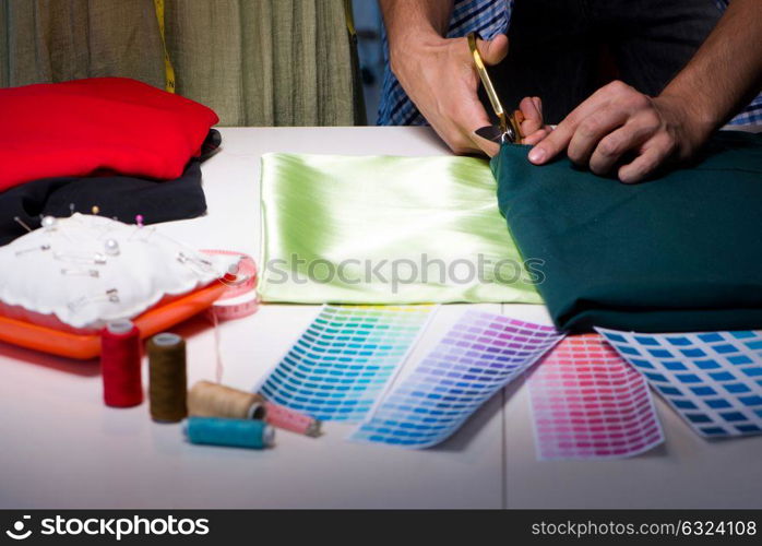 Male tailor working in sewer shop. The male tailor working in sewer shop