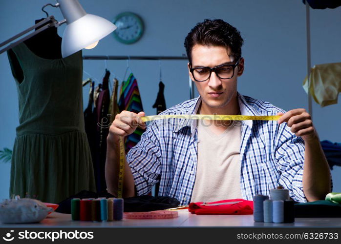 Male tailor working in sewer shop. The male tailor working in sewer shop