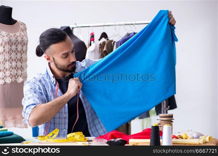 Male tailor working in the workshop on new designs