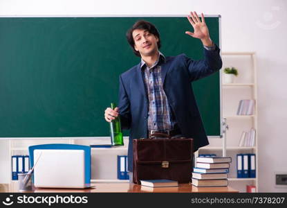 Male teacher drinking in the classroom 