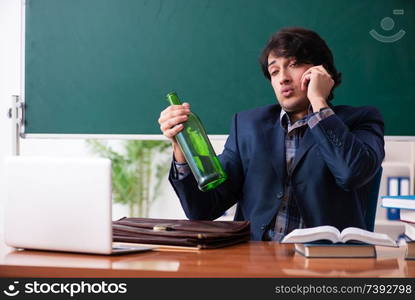 Male teacher drinking in the classroom 