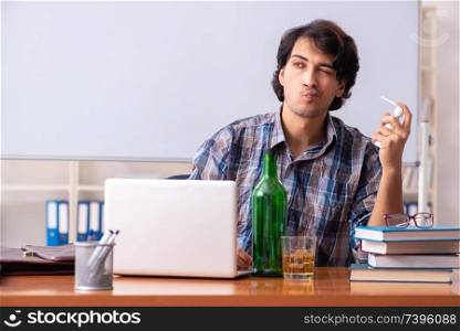 Male teacher drinking in the classroom
