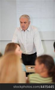 Male teacher stood at front of classroom