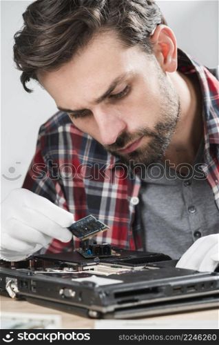 male technician examining laptop ram