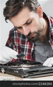 male technician examining laptop ram