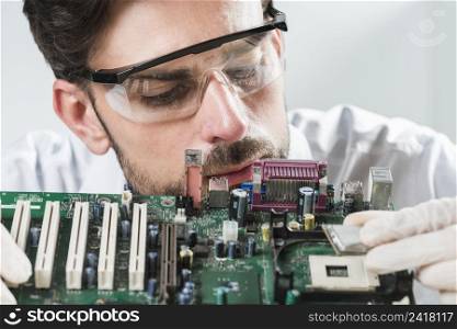male technician inserting chip computer motherboard
