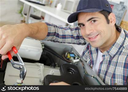 male technician repairing a digital photocopier machine