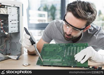male technician repairing computer circuit board