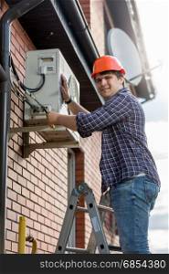 Male technician repairing outdoor air conditioning system