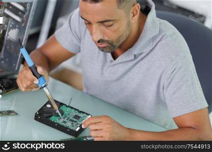 male technician soldering computer component