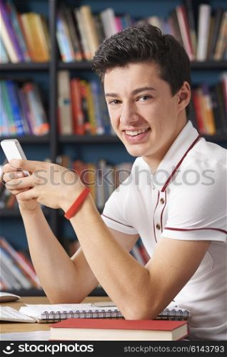 Male Teenage Pupil Texting In Classroom