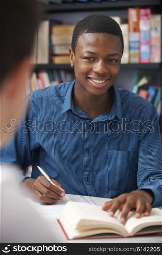 Male Teenage Pupil Working In Classroom