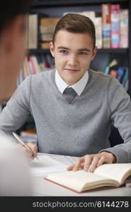 Male Teenage Student Working In Classroom