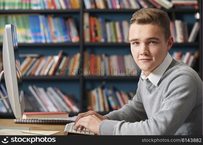 Male Teenage Student Working In Library