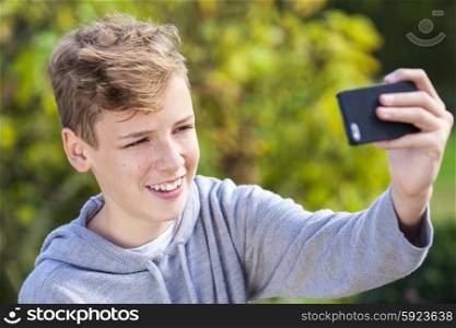 Male teenager boy teen child smiling and taking selfie photograph with cell phone
