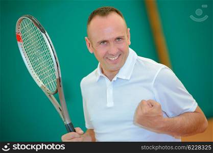 Male tennis player making gesture of victory