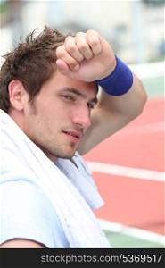 Male tennis player tired after match