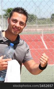 Male tennis player with bottle of water and towel
