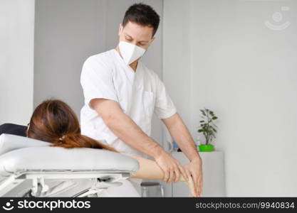 Male therapist giving massage to relief shoulder pain to a female patient in physiotheraphy clinic. High quality photo.. Male therapist giving massage to relief shoulder pain to a female patient in physiotheraphy clinic.