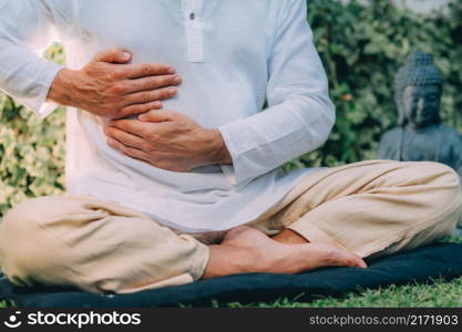 Male therapist performing reiki therapy self-treatment holding hands over his stomach. Alternative therapy concept. . Reiki Self-Healing Treatment