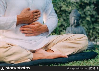 Male therapist performing reiki therapy self-treatment holding hands over his stomach. Alternative therapy concept. . Reiki Self-Healing Treatment