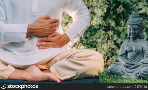 Male therapist performing reiki therapy self-treatment holding hands over his stomach. Alternative therapy concept. . Reiki Self-Healing Treatment